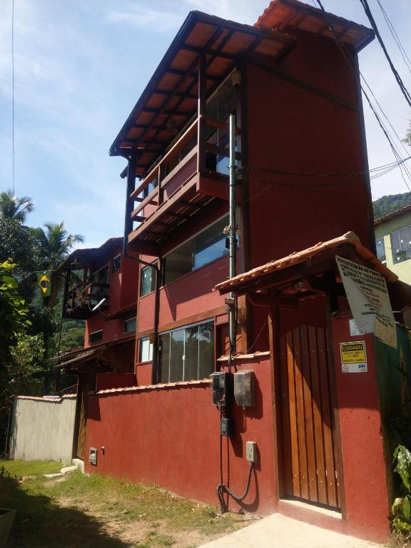 a red building with a balcony on the side of it at Mi casa Su casa Lofts - LOFT 5 in Angra dos Reis