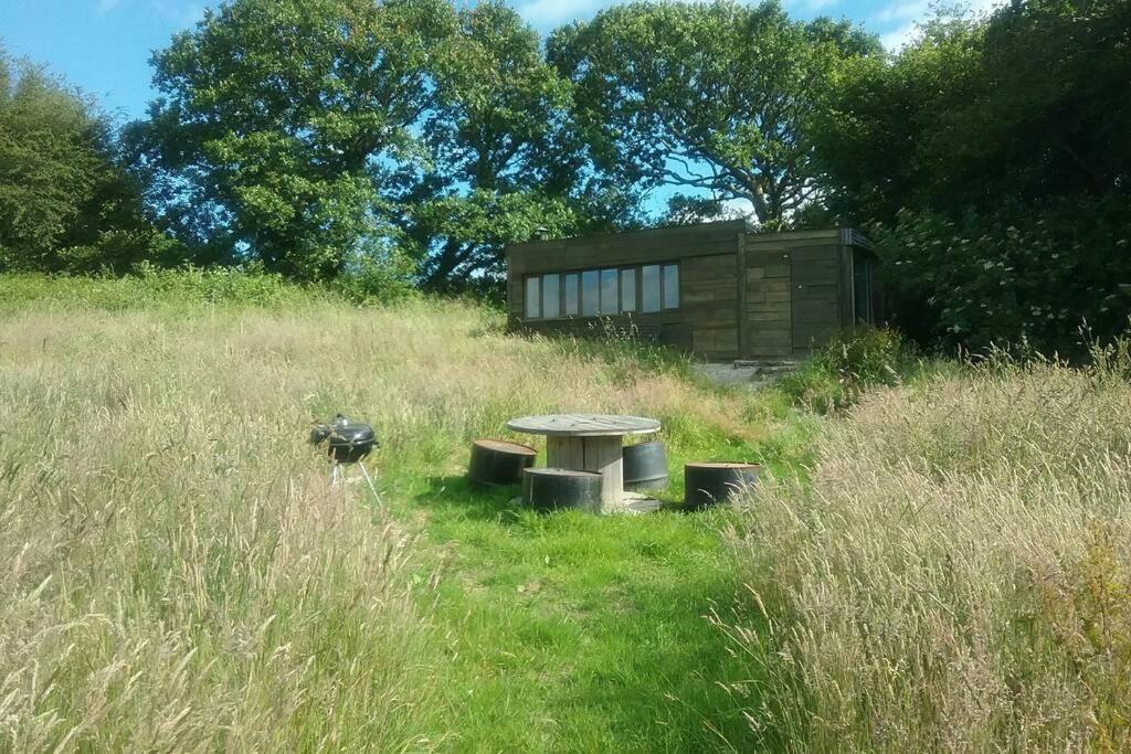 a picnic table in the middle of a field at Stags View,Unique eco cabin, Dartmoor views in South Brent