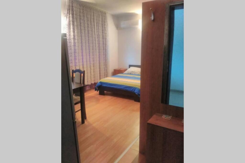 Zimmer mit einem Schlafzimmer mit einem Bett und einem Spiegel in der Unterkunft Приятный отдых в студии на море в Сарафово in Burgas City