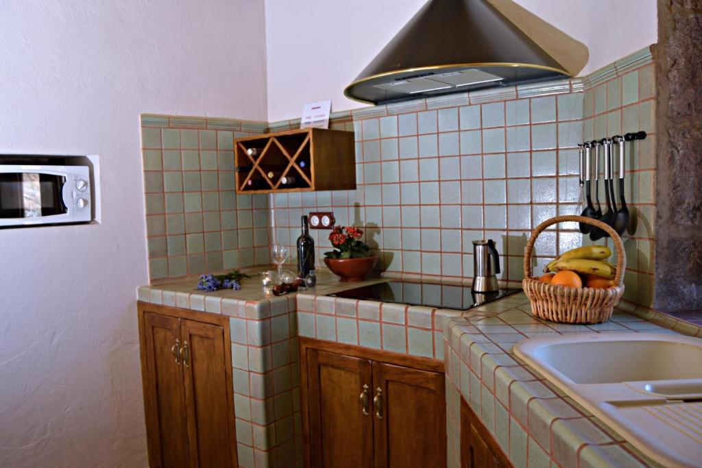 uma cozinha com um lavatório e um fogão forno superior em El Rinconcito de Tejeda em Tejeda