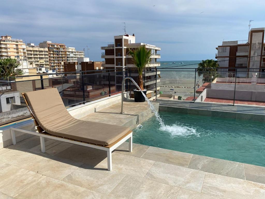 a chair sitting on top of a building with a fountain at Santa Pola Apartments in Santa Pola