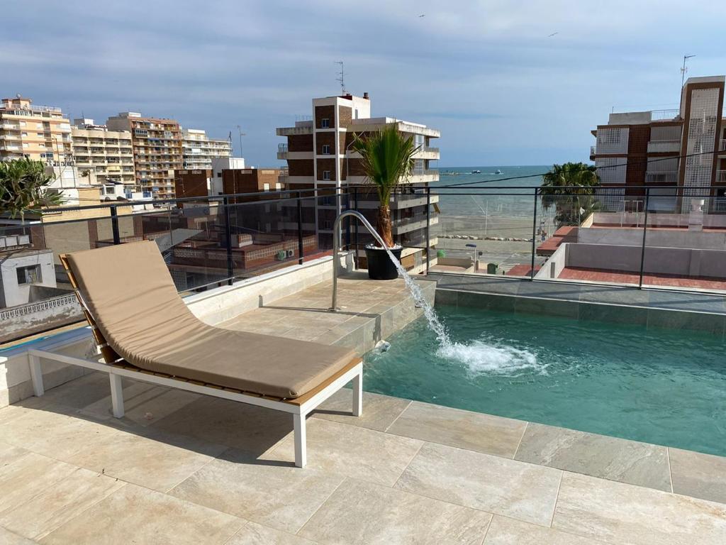 une chaise assise au-dessus d'un bâtiment avec une fontaine dans l'établissement Santa Pola Apartments, à Santa Pola