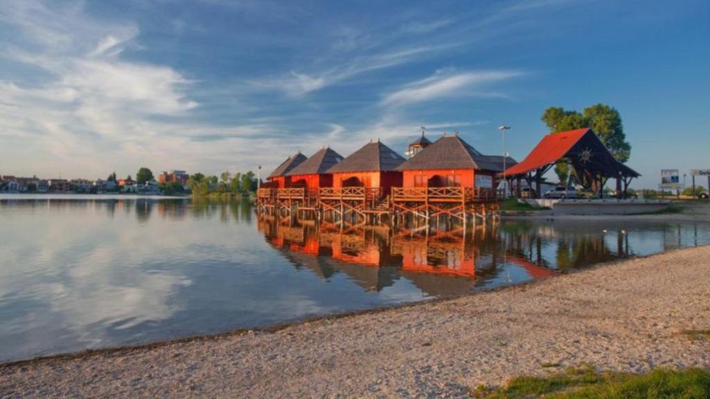 a building on the water with its reflection in the water at Overwater cottage - Slovak Tahiti, Senec in Senec