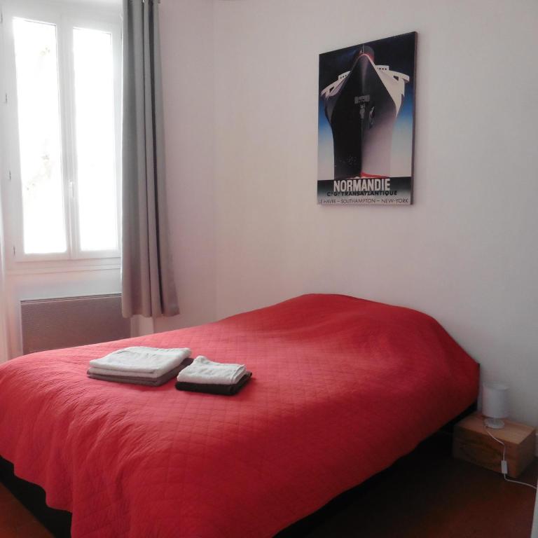 a bedroom with a red bed with two towels on it at Villa Zola in Aix-en-Provence