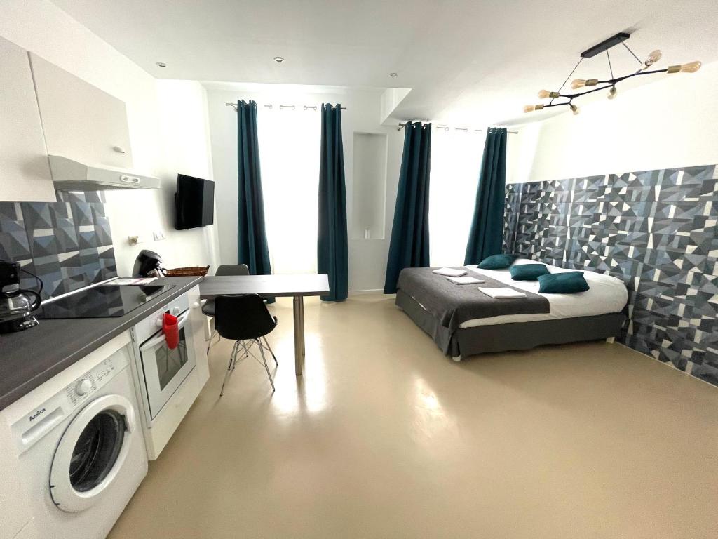 a bedroom with a bed and a kitchen with a washing machine at Studio 11 Panier Vieux Port Roof Top in Marseille