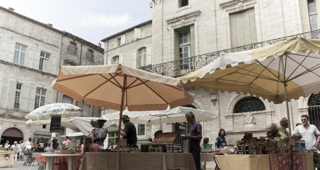 a group of people standing under umbrellas on a street at "Le Patio"-Meublé de Tourisme 3 étoiles -Résidence "Les Logis de Béziers"-Garage optionnel-Cœur de ville-Plages à 16km ! in Béziers