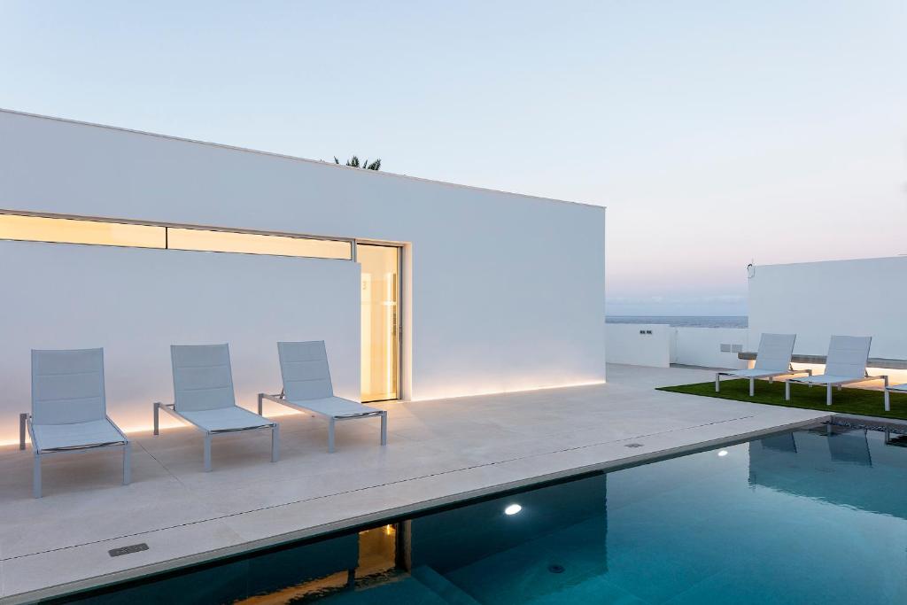 una casa con piscina e sedie accanto di Remote workers paradise@the Atlantic a Candelaria