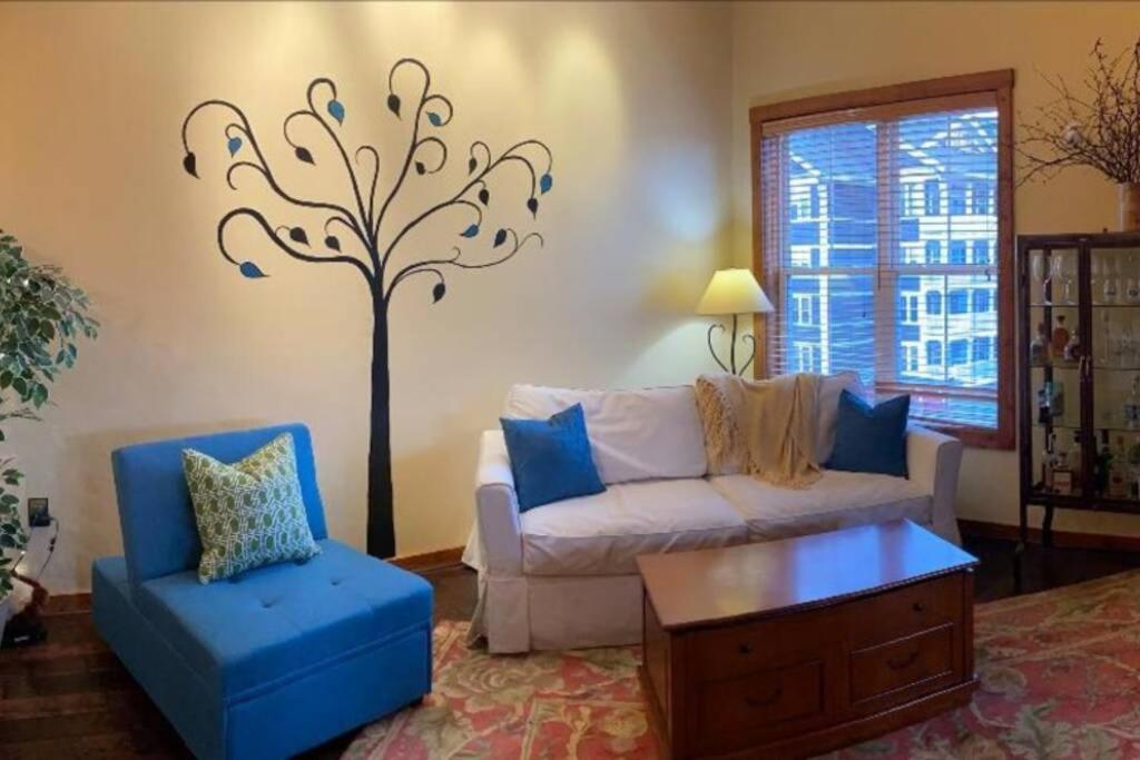 - un salon avec un canapé et un arbre sur le mur dans l'établissement 'The Treehouse' at Snowshoe - Village & Slope View, à Snowshoe