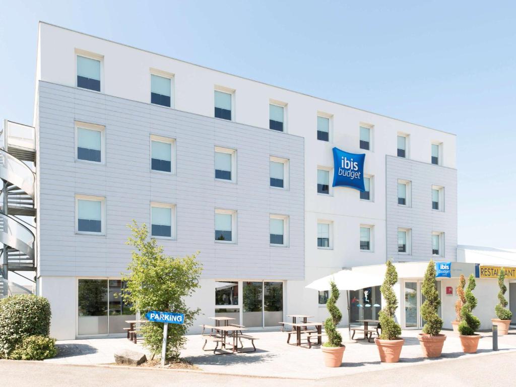 a white building with a blue sign on it at Hotel Ibis Budget Lyon Eurexpo - in Chassieu