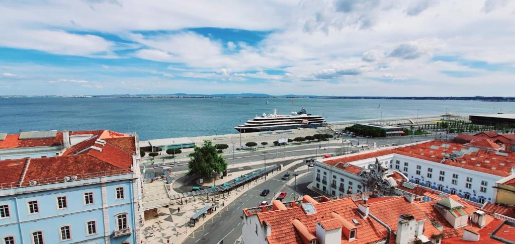 un crucero está atracado en el agua con edificios en RA PARAISO en Lisboa