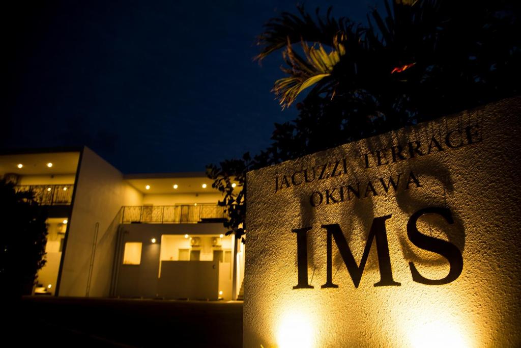 a sign in front of a building at night at Jacuzzi Terrace Okinawa IMS in Motobu