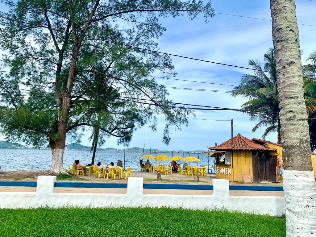 un grupo de personas sentadas en un restaurante junto al agua en Cantinho dos Amigos en São Pedro da Aldeia