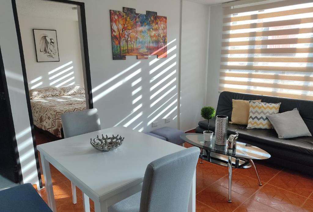uma sala de estar com uma mesa branca e um sofá em CASA AVILA - Apartamento amoblado 1 - Villa Alsacia em Bogotá