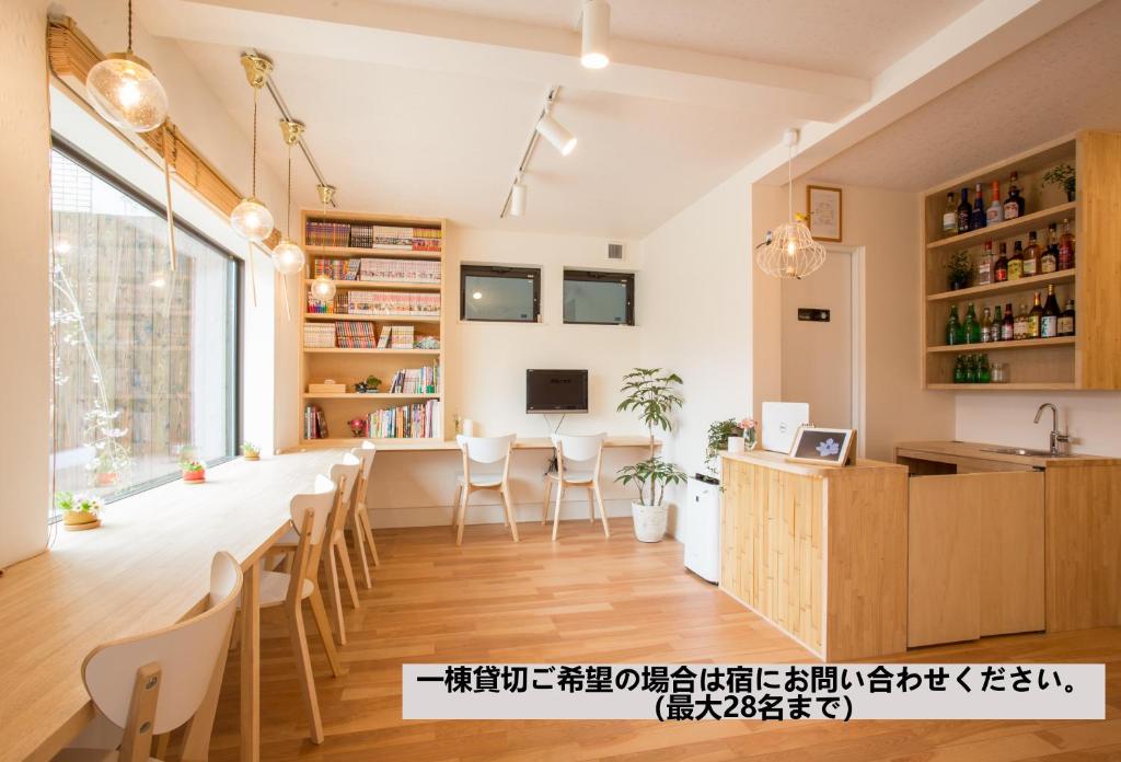 Mulan Hostel في كيوتو: مطبخ وغرفة طعام مع طاولة وكراسي