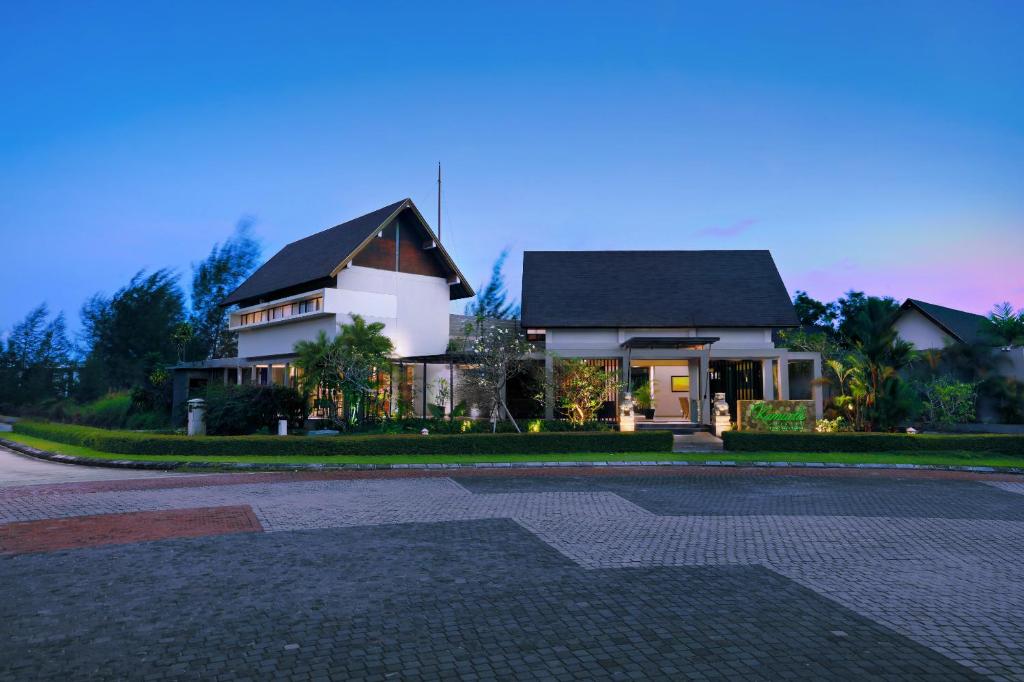 a white house with a black roof on a street at Kamuela Villa Lagoi Bay Bintan in Lagoi