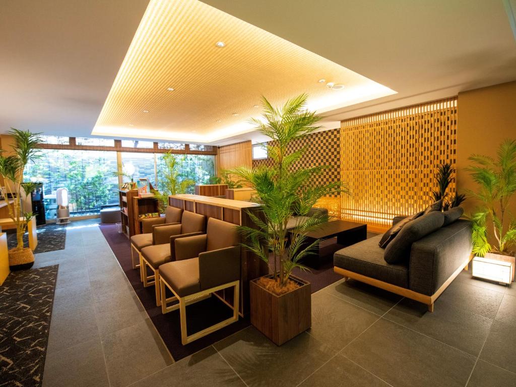 a lobby of a hotel with chairs and a bar at Homm Stay Nagi Sanjo Kyoto By Banyan Group in Kyoto