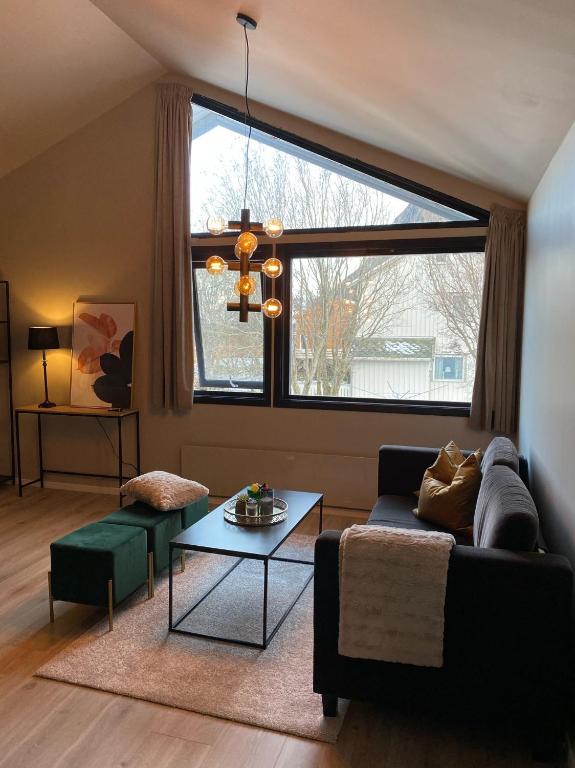 a living room with a couch and a large window at Reine City Apartment in Reine