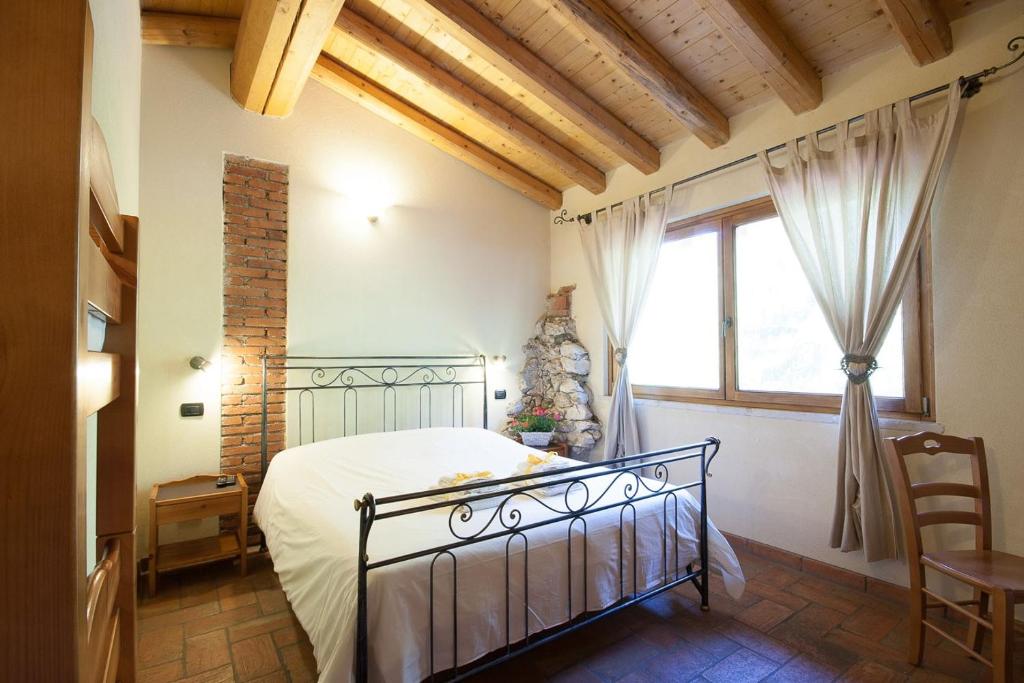 - une chambre avec un lit et une grande fenêtre dans l'établissement Agriturismo BioBiò, à Vobarno