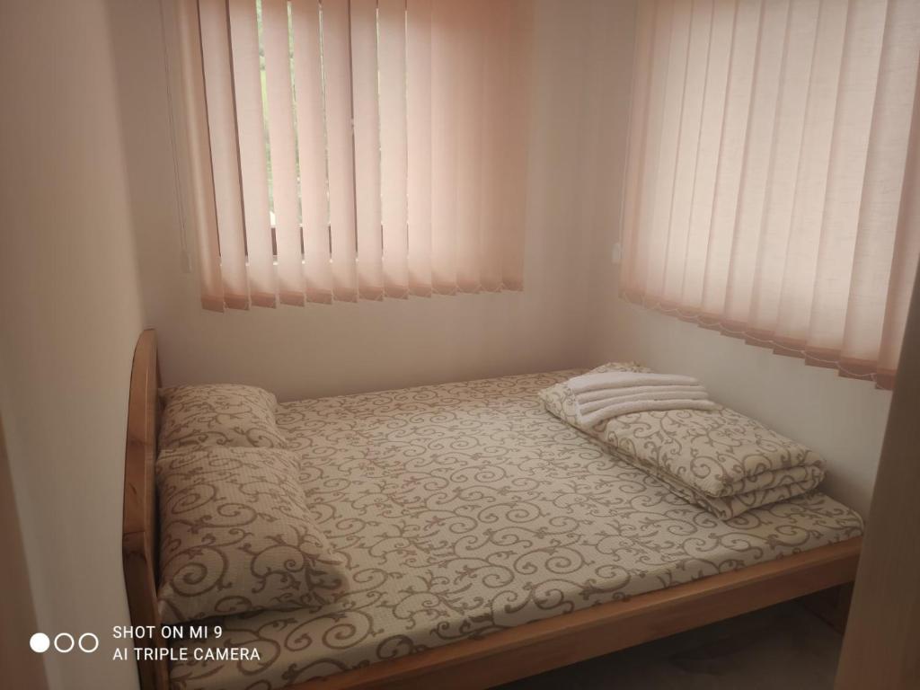 a small bed in a room with a window at Apartmani ODMOR NA DRINI in Ljubovija