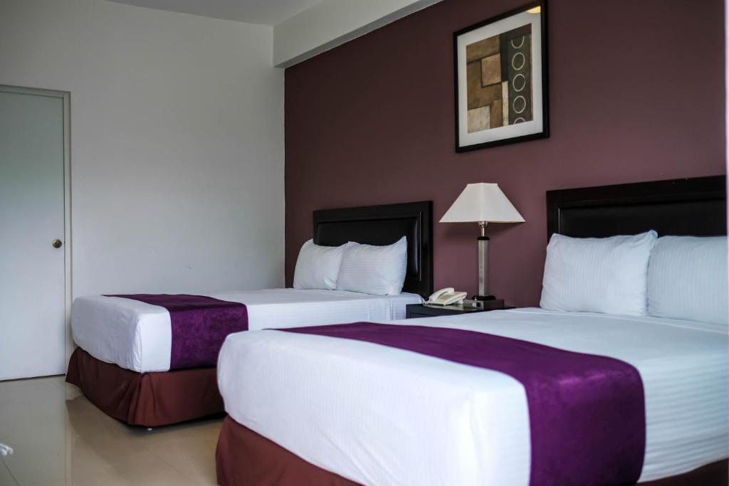um quarto de hotel com duas camas e um candeeiro em Hotel Las Vegas em Poza Rica de Hidalgo