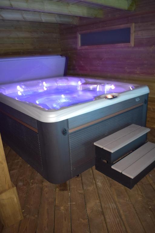 eine Whirlpool-Badewanne mit Beleuchtung in einem Zimmer in der Unterkunft BOUILLON - Gîte wellness Dans l air du vent in Sensenruth