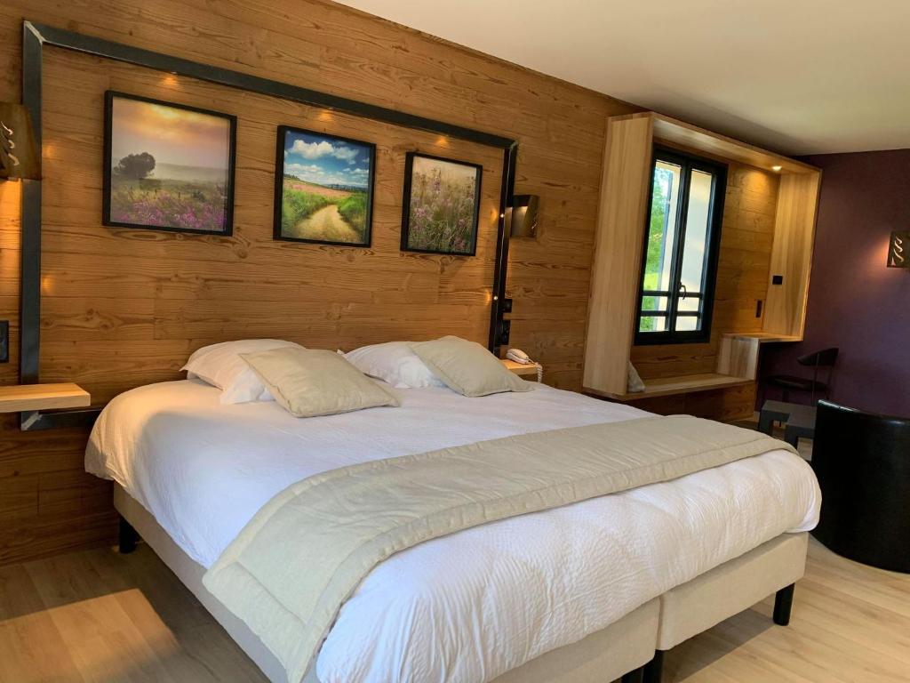 a bedroom with a large white bed in a room at hotel des Sapins in Lanarce