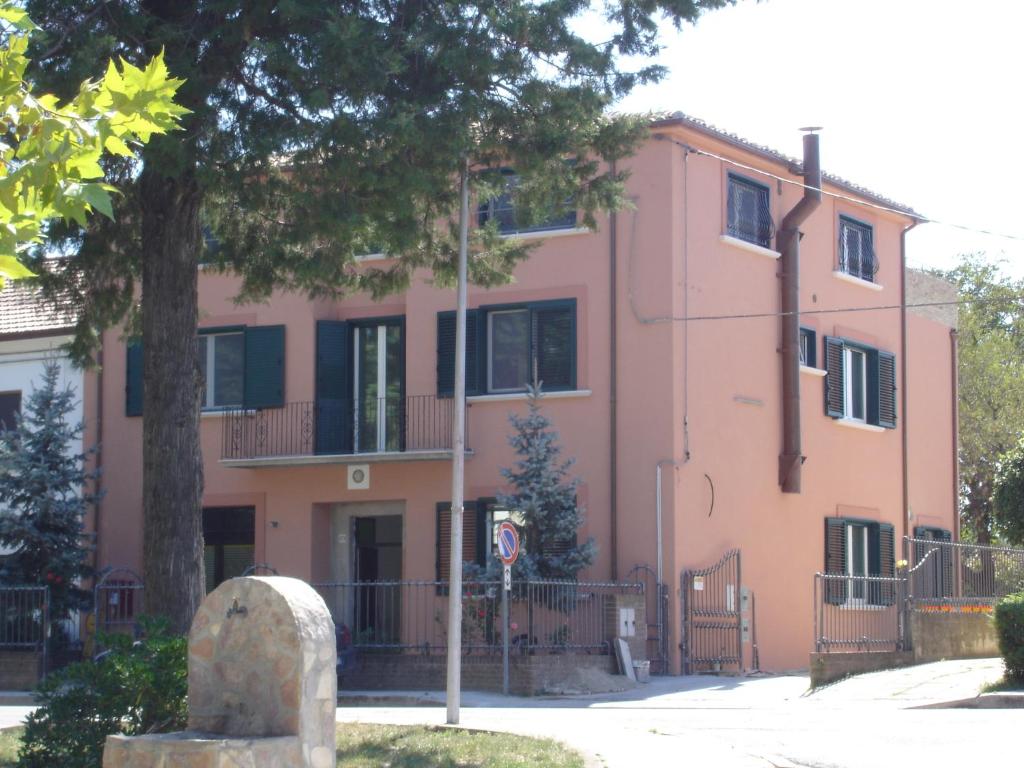 un bâtiment rose avec un arbre devant lui dans l'établissement Villa San Giacomo, à Scerni