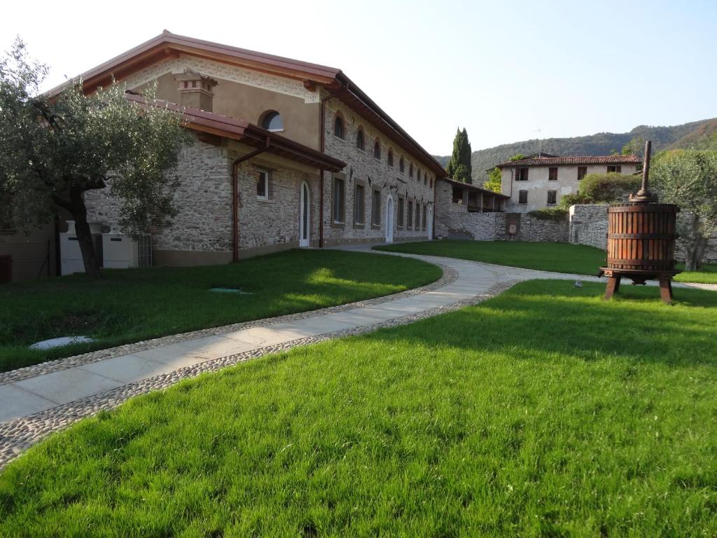 einen Gehweg vor einem Gebäude mit grünem Rasen in der Unterkunft Agriturismo Milord in Salò