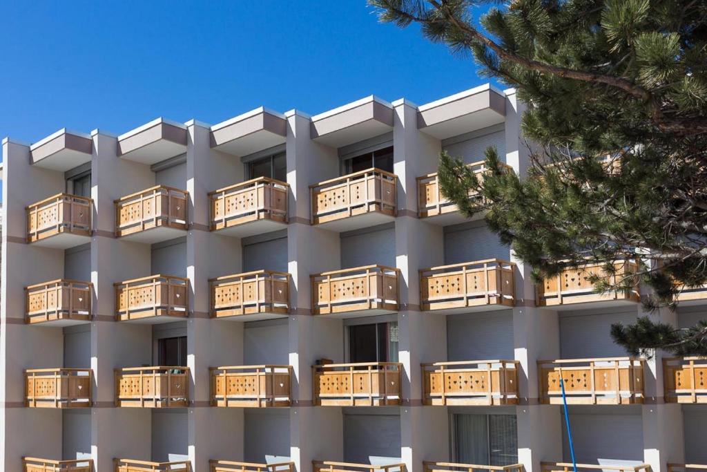 an apartment building with wooden balconies on it at Vacancéole - Résidence Le Sappey - Les 2 Alpes in Les Deux Alpes