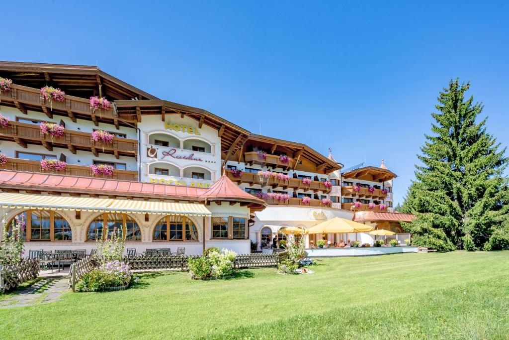 un grand bâtiment avec une pelouse devant lui dans l'établissement Hotel Residenz Hochland, à Seefeld in Tirol
