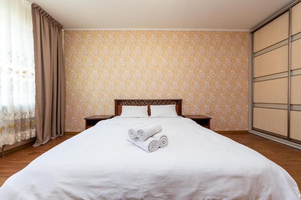 ein Schlafzimmer mit einem weißen Bett mit zwei Handtüchern darauf in der Unterkunft Елизаветы Чавдар 34 in Kiew