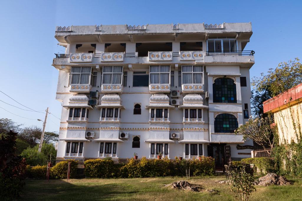 a large white building with a lot of windows at Hotel Sargam Sadan in Udaipur