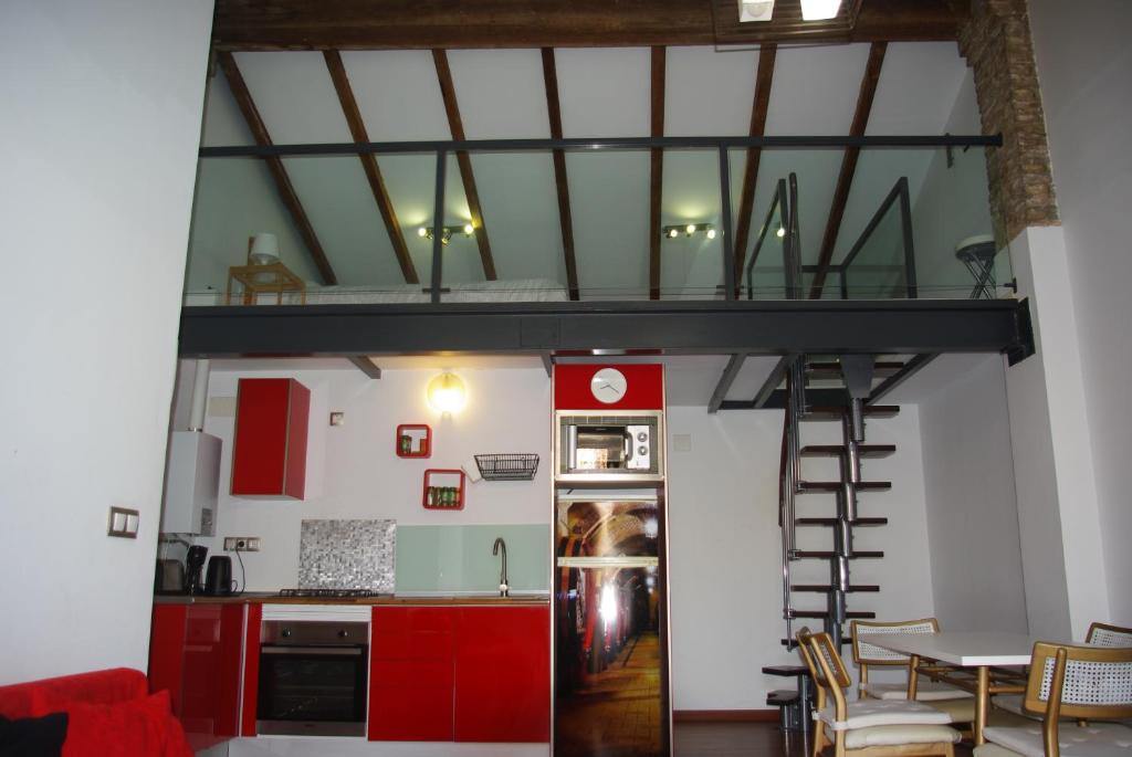 a kitchen with red cabinets and a loft bed at Apartamento Centro Valencia in Valencia