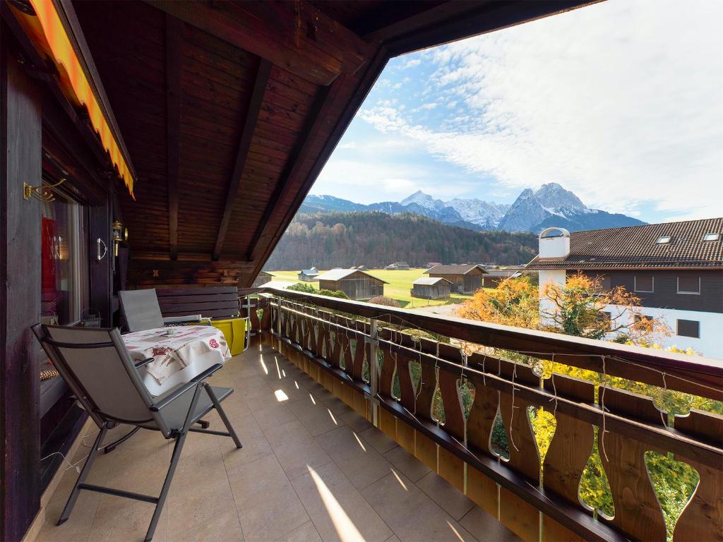a balcony with a chair and a view of mountains at Chalet Alpenglühen in Garmisch-Partenkirchen