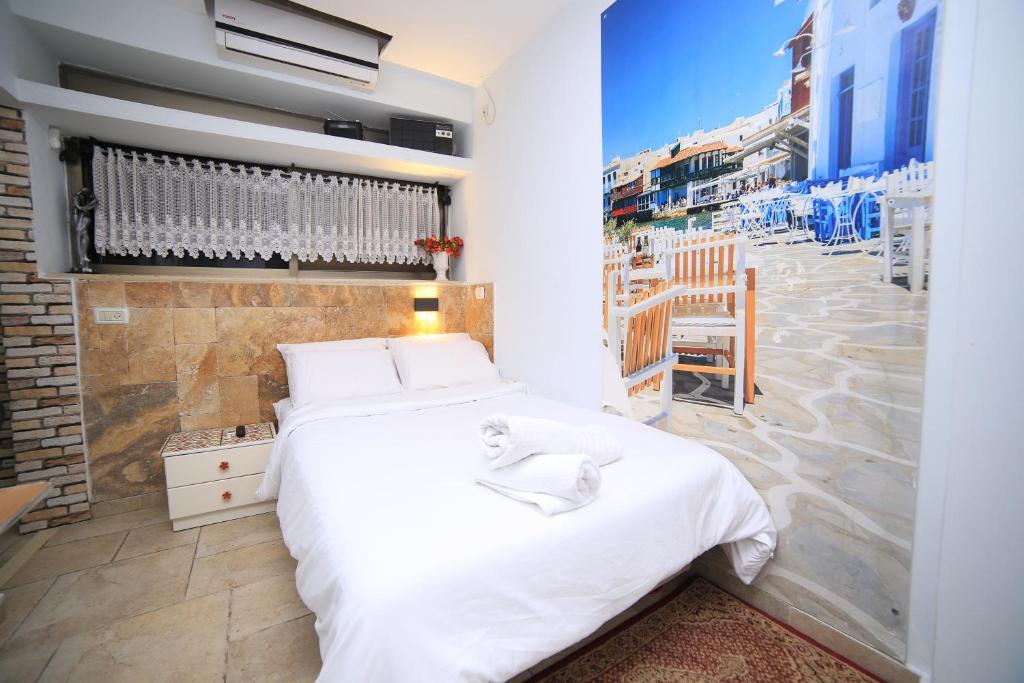 - une chambre avec un lit blanc et une vue sur la ville dans l'établissement Ahuzat Shaul - Studio, à Hadera