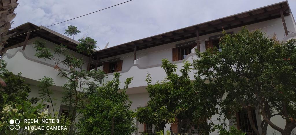 a white building with trees in front of it at Arki Island-Katsavidis in Arkoi