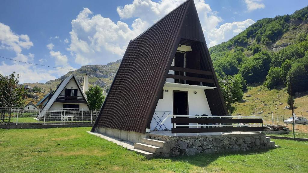 a small church with a black roof at Katun Mokra accommodation & horseback riding in Podgorica