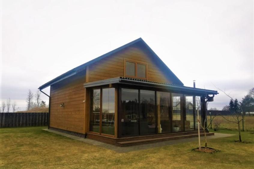 a small house with a blue roof and windows at Arturas Guest House in Vilnius