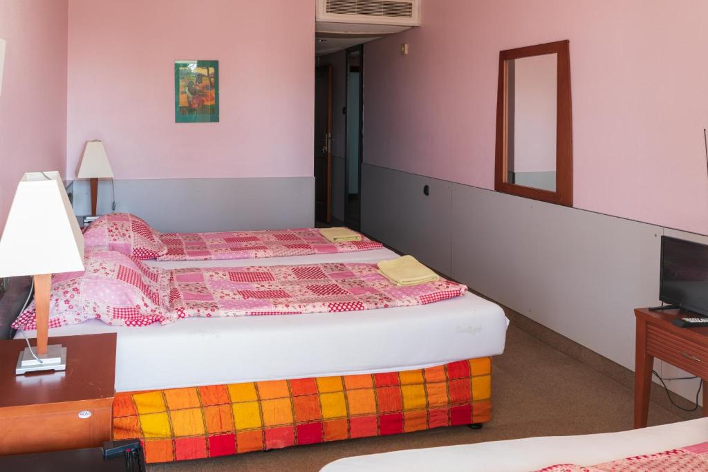 A bed or beds in a room at Négy Évszak Panziò