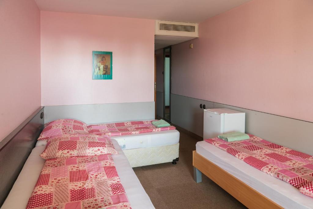 A bed or beds in a room at Négy Évszak Panziò