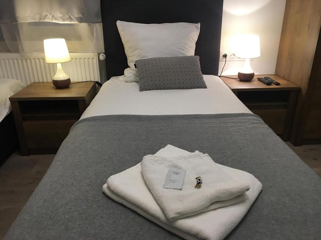 łóżko z białymi ręcznikami i laptopem w obiekcie Aranykorona Apartmanház w Miszkolcu