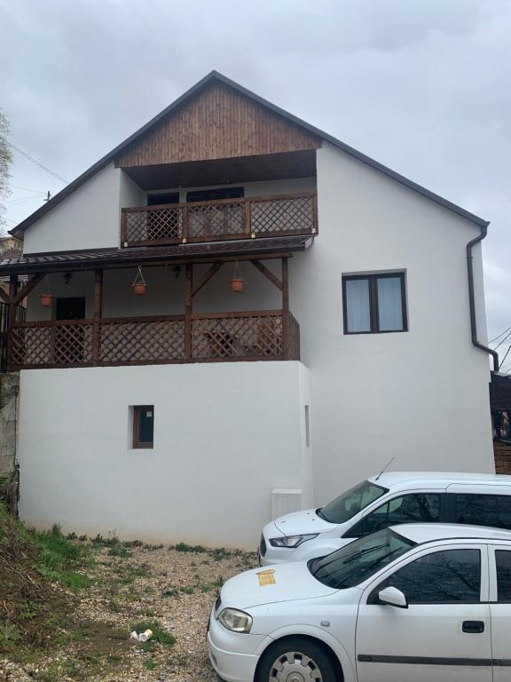 Biały dom z dwoma samochodami zaparkowanymi przed nim w obiekcie Aranykorona Apartmanház w Miszkolcu