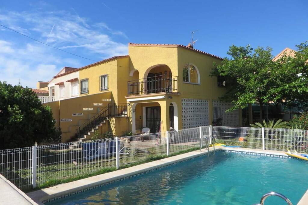 uma casa com piscina em frente a uma casa em Villa exclusiva cerca del mar con Piscina privada em Benicàssim