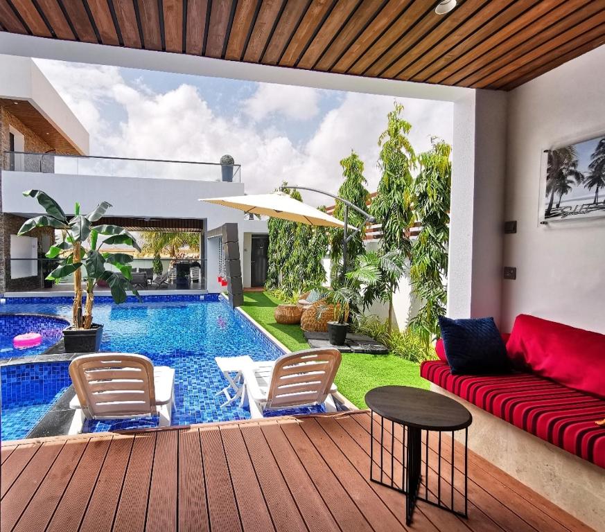 a living room with a red couch and a pool at G R A N D C H A L E T in Salalah