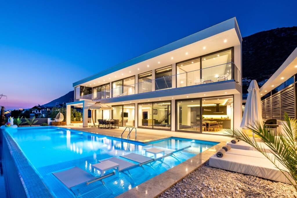 a large house with a swimming pool in front of it at Luxury Villa for 8 with 20m large Infinity Pool in Kalkan in Kaş