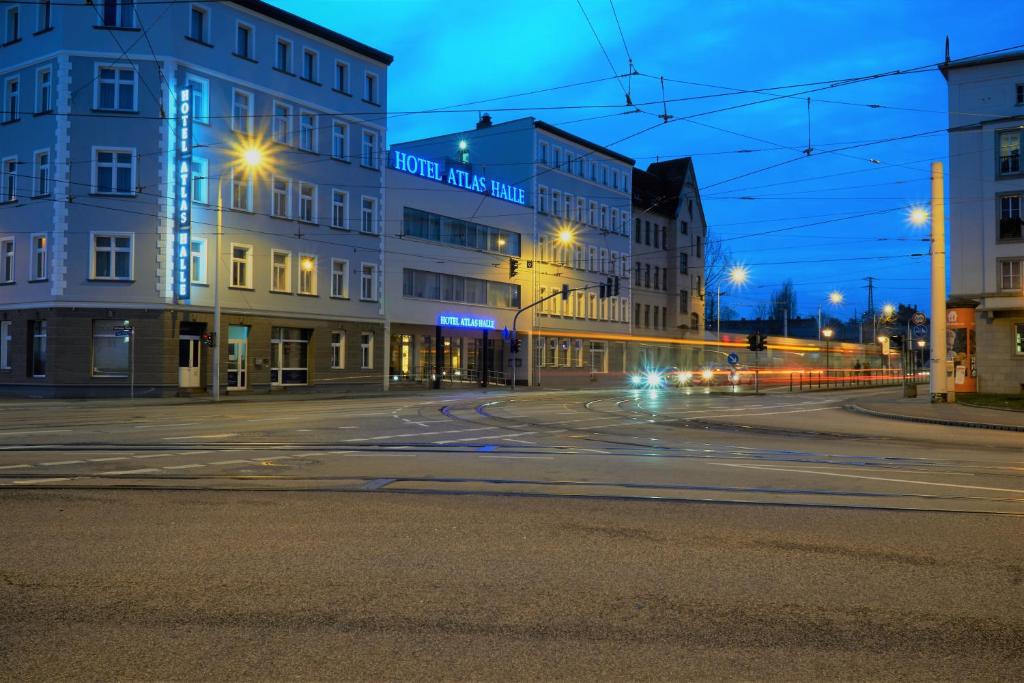 eine leere Stadtstraße in der Nacht mit Gebäuden in der Unterkunft Hotel Atlas Halle in Halle an der Saale