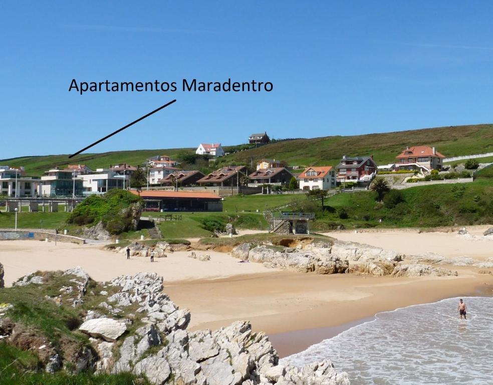 ソト・デ・ラ・マリーナにあるApartamentos Maradentroの水中の人々の集まりがある海岸