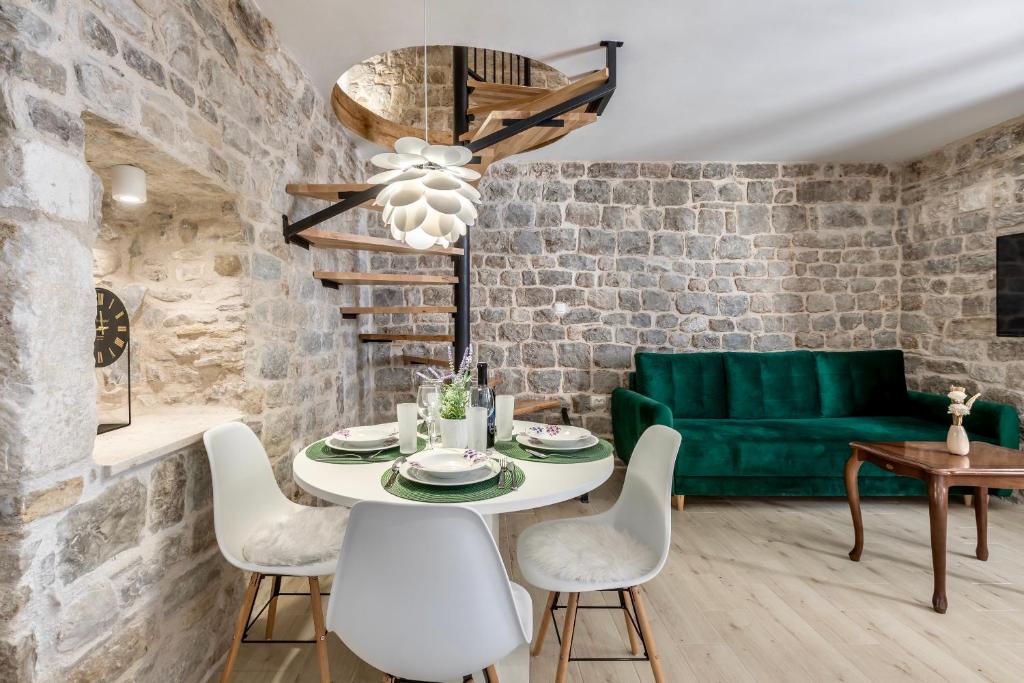a living room with a table and a green couch at D & D Luxury Apartment in Kaštela