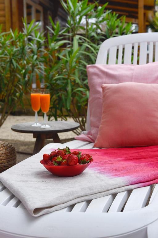a bowl of strawberries on a table with two glasses of juice at Sas Robrecht in Saint-Tropez