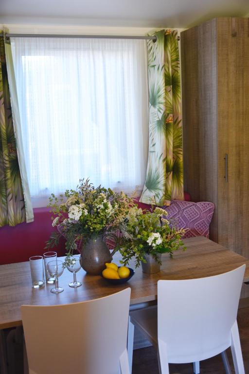 a dining room table with a vase of flowers on it at Sas Robrecht in Saint-Tropez